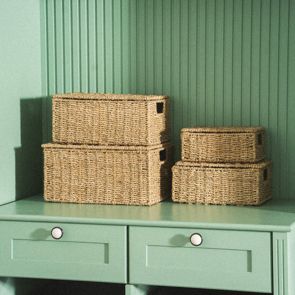 four-brown-seagrass-wicker-storage-baskets-of-different-sizes-arranged-on-a-mint-green-table