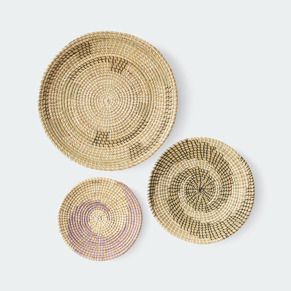 Set of three round woven wall baskets in natural, brown, and purple colors with hanging rope by Artera Home