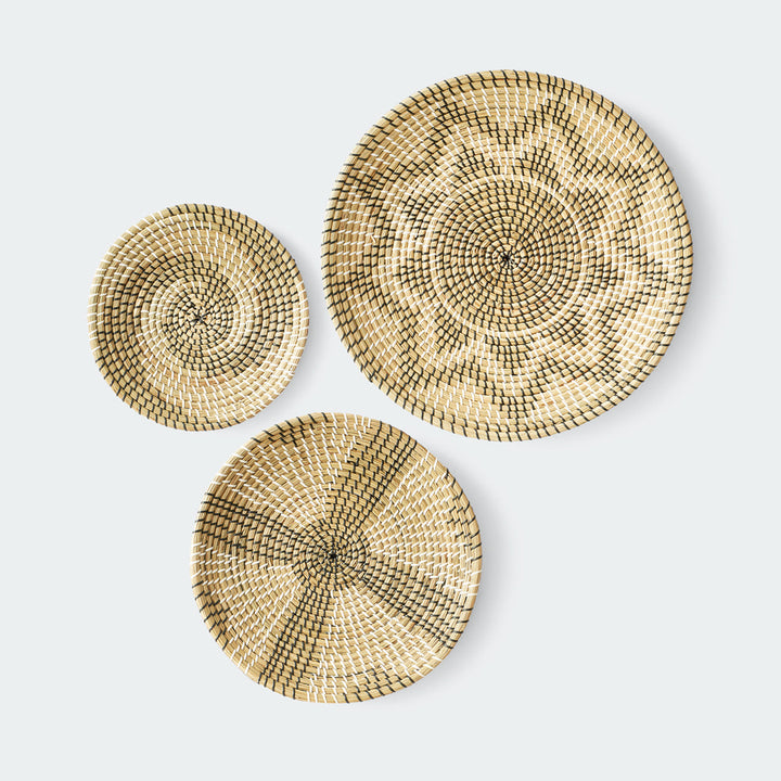 Set of 3 round woven baskets with symmetrical radiating patterns in beige and dark brown by Artera Home