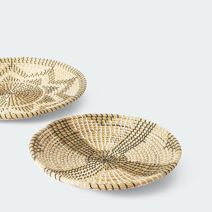 Set of 3 round woven baskets with symmetrical radiating patterns in beige and dark brown by Artera Home