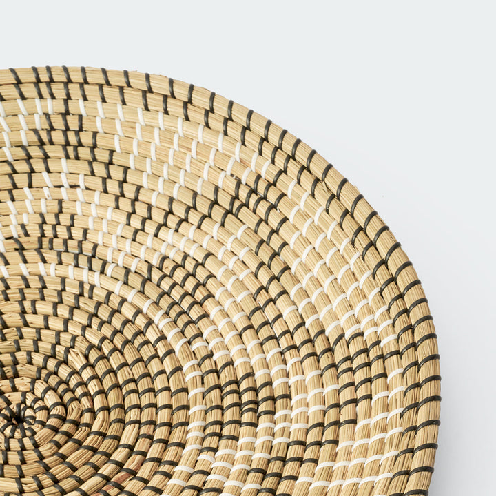 Set of 3 round woven baskets with symmetrical radiating patterns in beige and dark brown by Artera Home