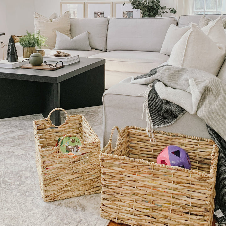 A large water hyacinth wicker basket filled with toys on the floor