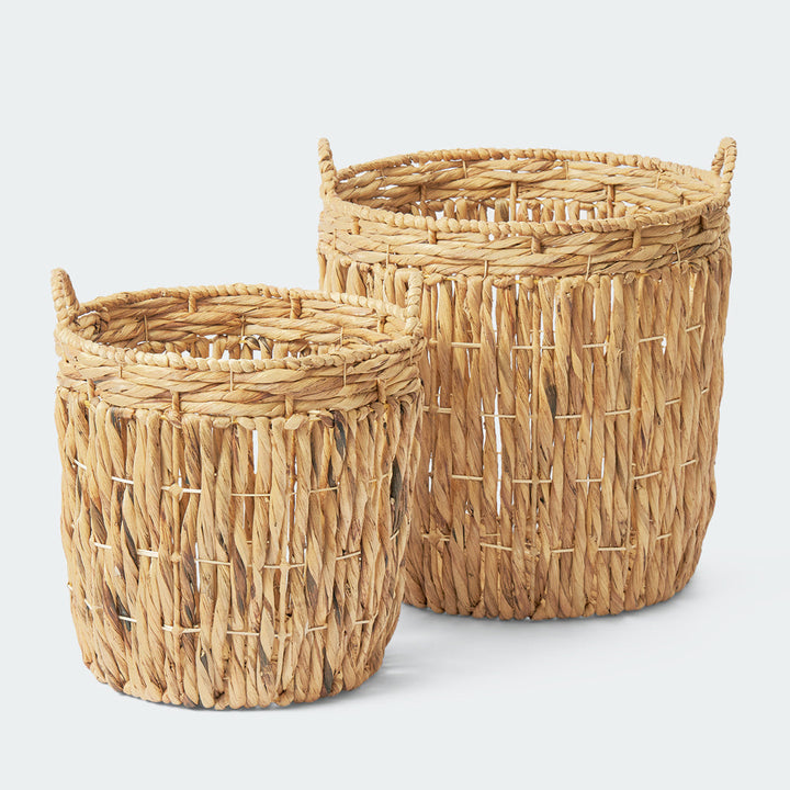 Two cylindrical wicker storage baskets with thick, twisted handles, showcasing their sturdy, handwoven construction