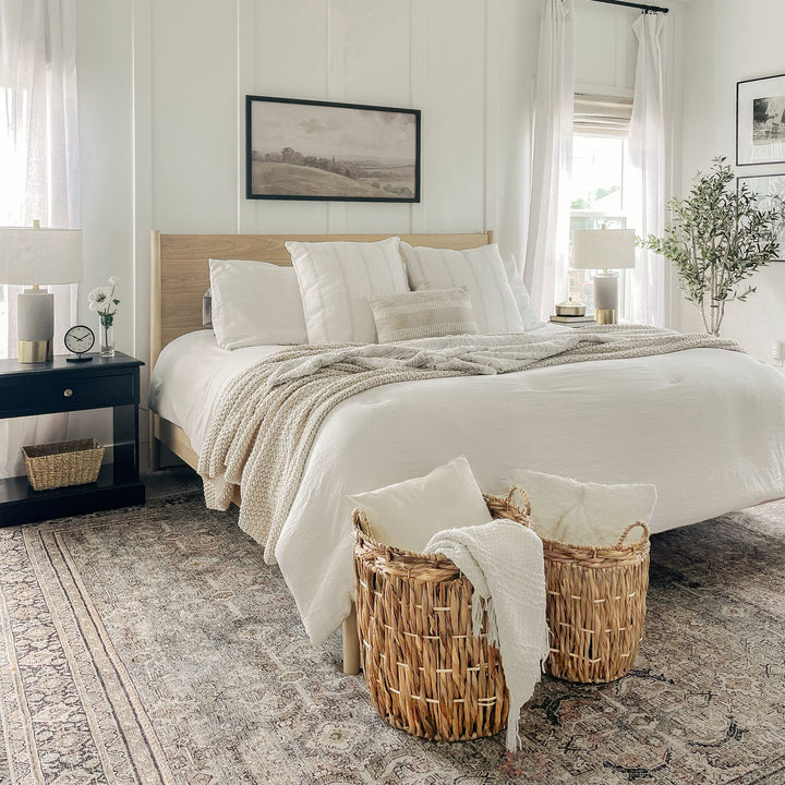 A cozy bedroom with two cylindrical wicker storage baskets placed by the bed