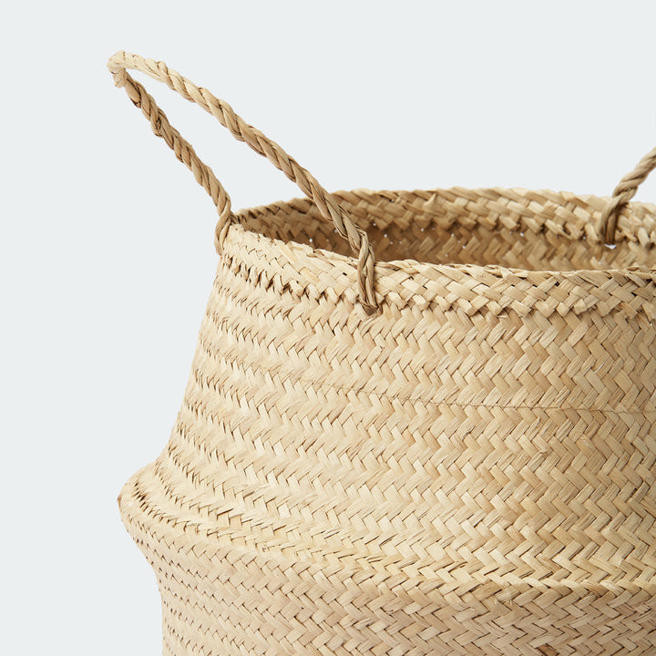 A close-up look at a neutral seagrass wicker vase planter with weaving handles