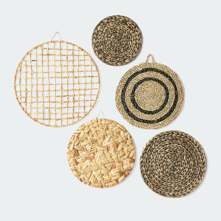 A collection of five round wall hangings, each with a unique woven pattern, mixed seagrass and water hyacinth
