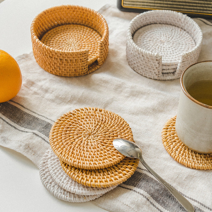 Woven-coasters-in-honey-brown-and-white-tones-neatly-stacked-in-matching-holders-offer-a-stylish-and-practical-solution