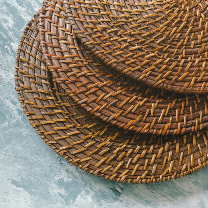 A-stack-of-dark-brown-wicker-charger-plates-
highlighting-their-textured-pattern