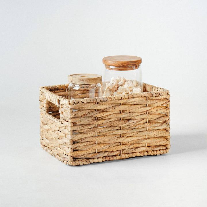 A close-up of a water hyacinth wicker storage basket with built-in handles