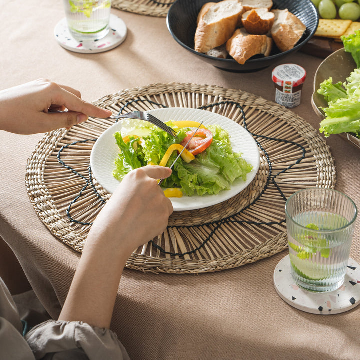 Set of 6 round wicker placemats with black sun-like thread design