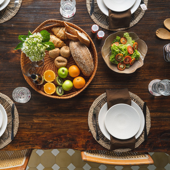 Set of 6 round wicker placemats with black sun-like thread design