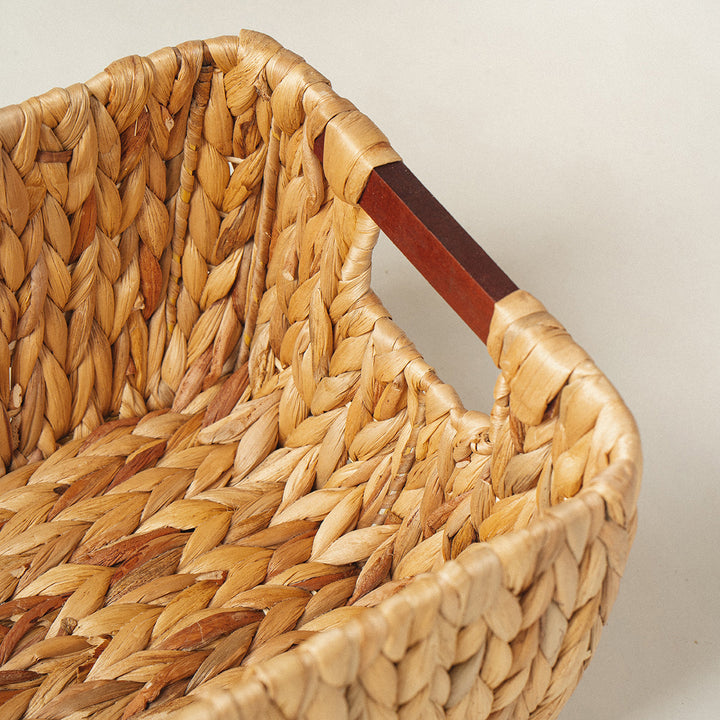 A front look at a rectangle arrow water hyacinth wicker storage basket with wooden handles